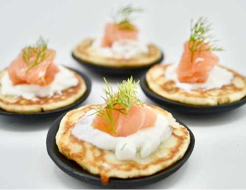 Smoked Salmon — Smoked salmon served on mini blinis with cream cheese and dill.